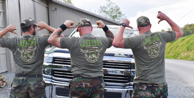 Three people in camo shirts flexing in front of a chrome pickup truck outdoors