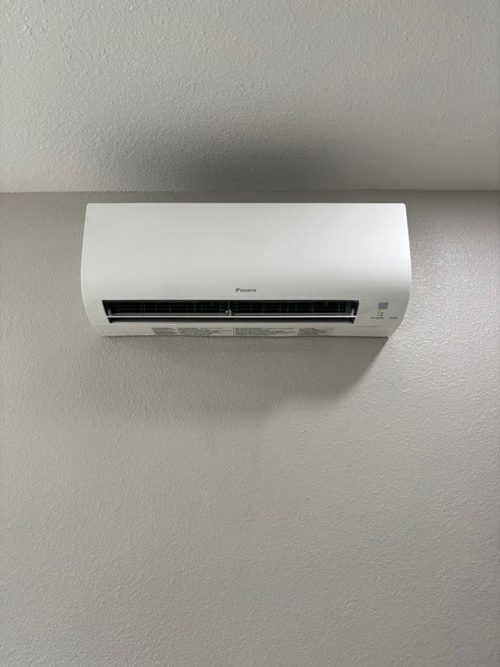 White wall-mounted air conditioner on a light gray wall