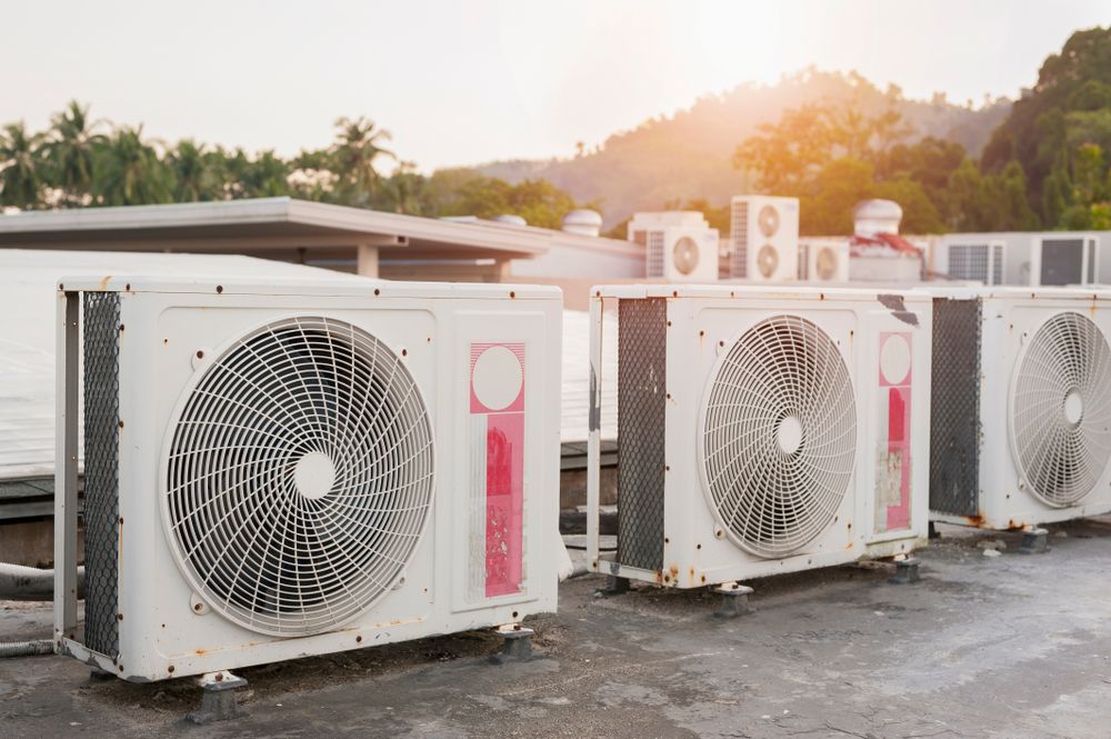 Outdoor air conditioner units on a rooftop at sunset