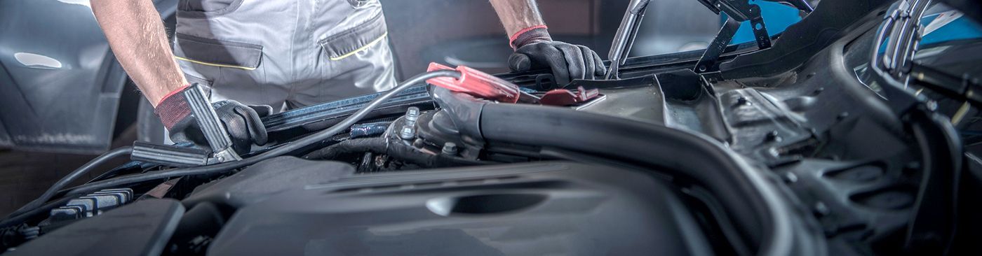 A man is working on the engine of a car.