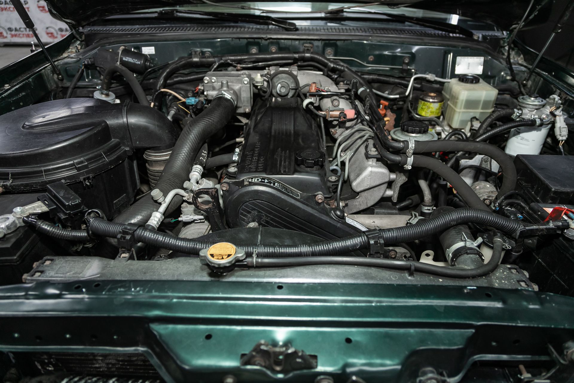 A close up of a car engine with the hood open.