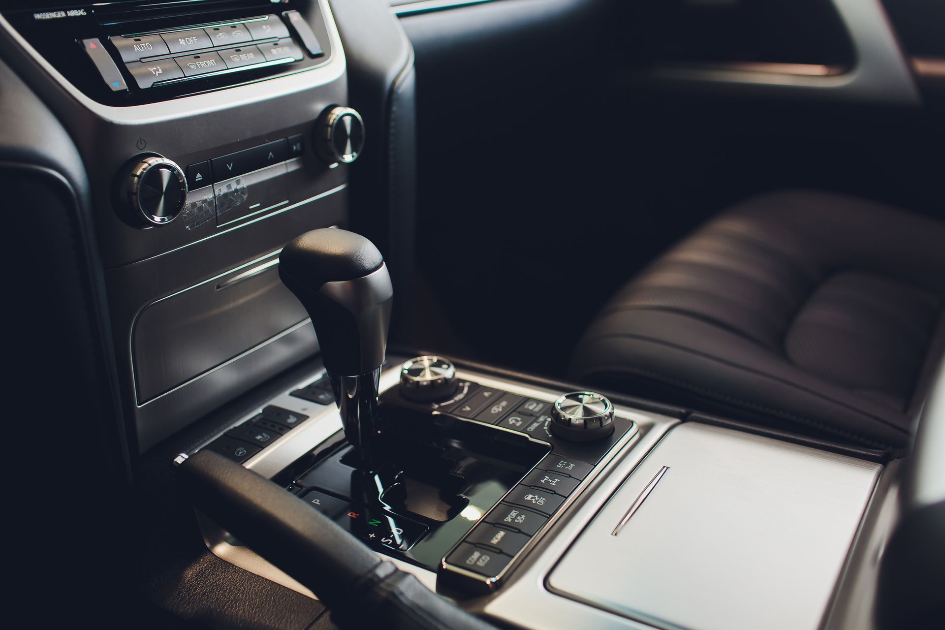 The interior of a car with a shifter and a radio.