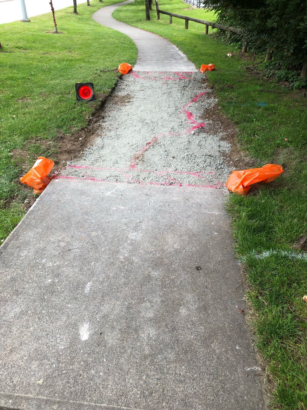 Wet concrete pouring from a truck chute onto a construction site, forming a gravelly slab surface