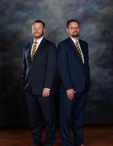 two men in suits and ties are standing next to each other .