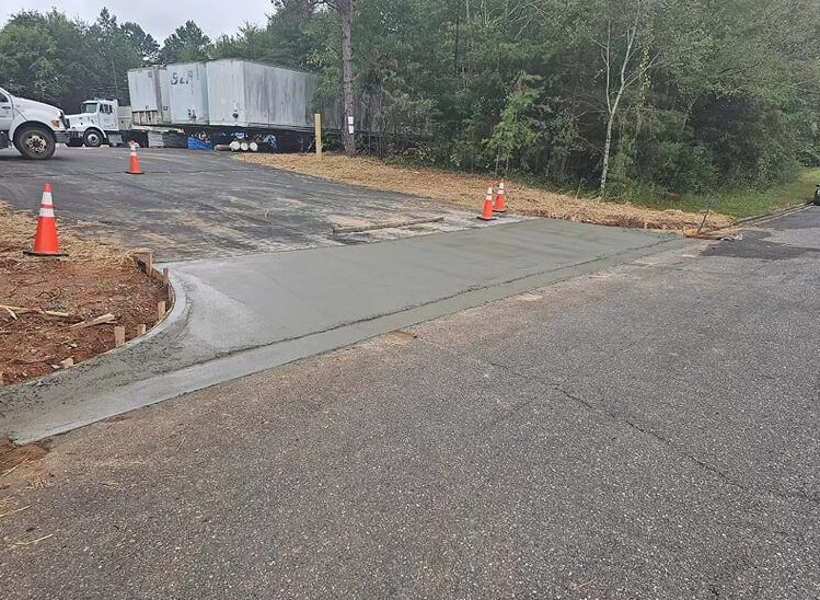 A truck is parked on the side of the road next to a concrete curb.