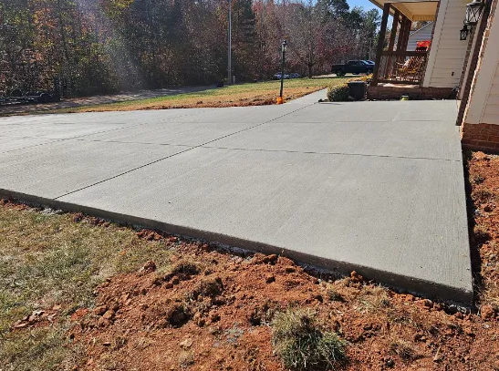 A concrete driveway is being built in front of a house.