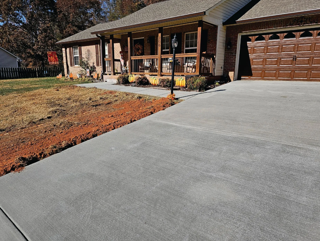 A house with a concrete driveway in front of it