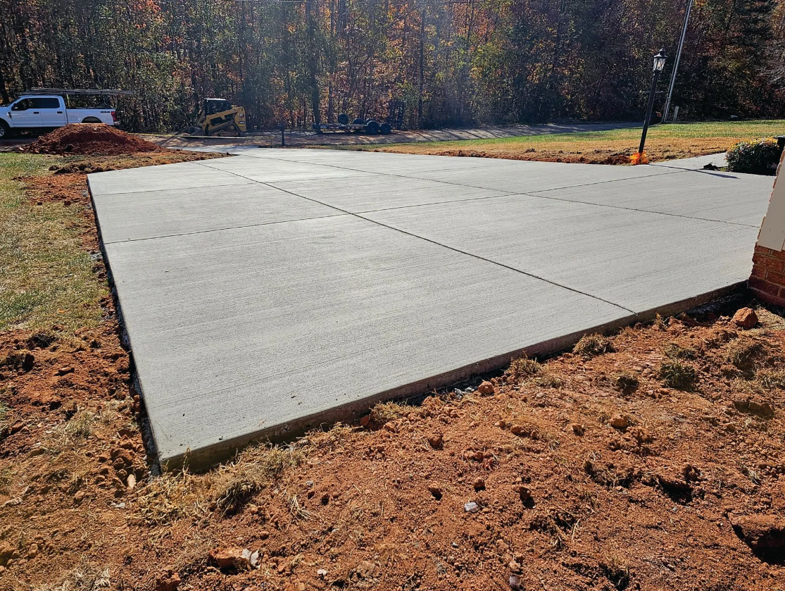 A large concrete slab is sitting in the middle of a dirt field.