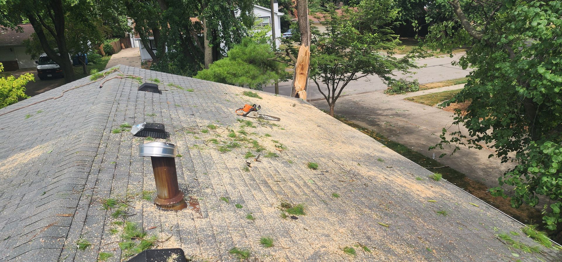 A roof with a chimney on it and trees in the background.
