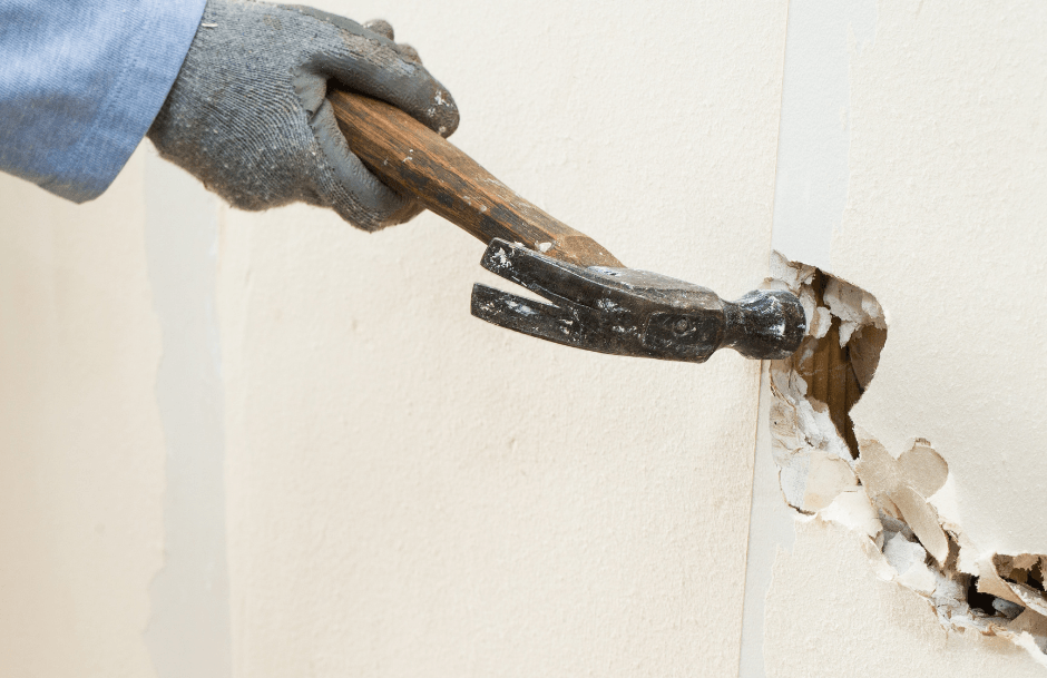 Photo of a hammer damaging drywall.