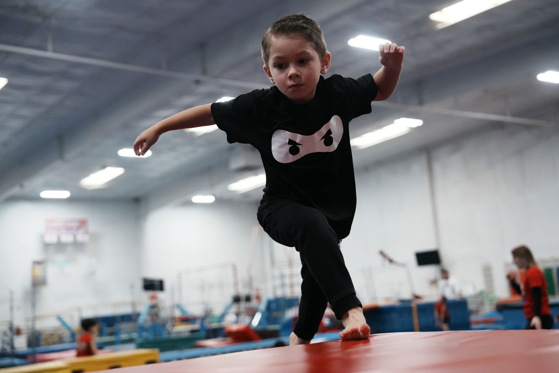 NinjaZone kid leaping across the gym floor at American Kids Sports Center in Bakersfield