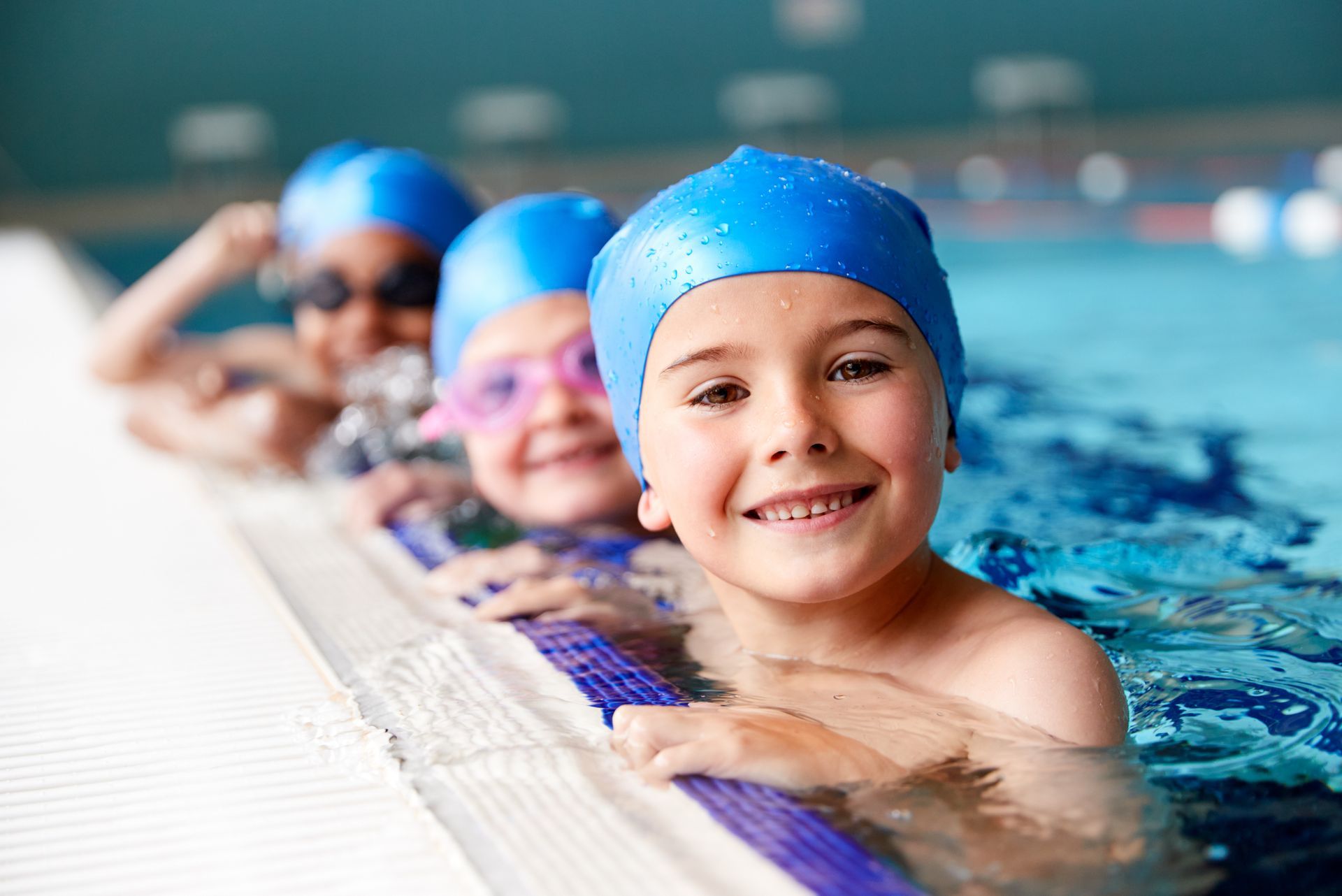 A group of children are swimming in a swimming pool.