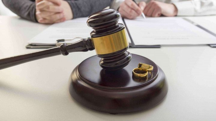 Hands of wife husband signing a file in front of a gavel