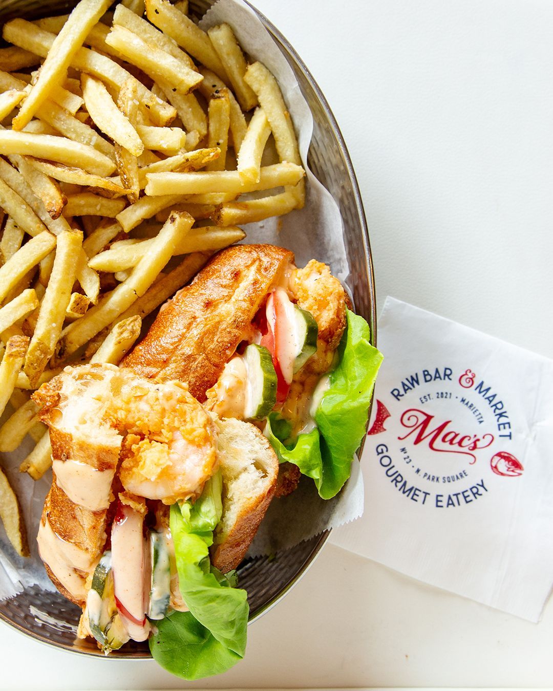 A plate of food with a sandwich and french fries from mac 's gourmet eatery