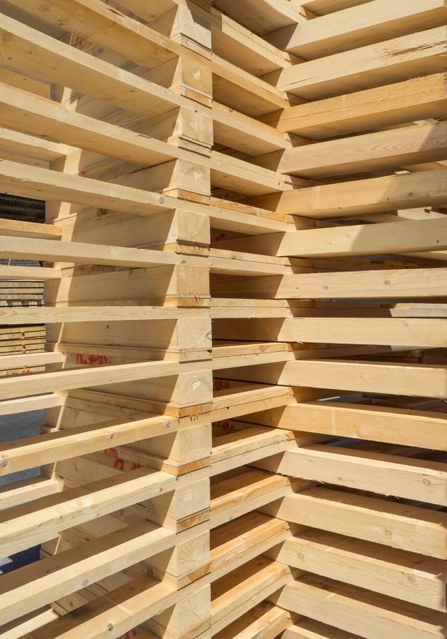 Stack of wooden pallets, viewed at an angle with visible slats and supports.