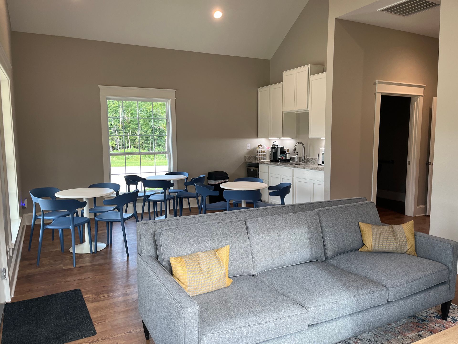 A living room with a couch , tables and chairs.