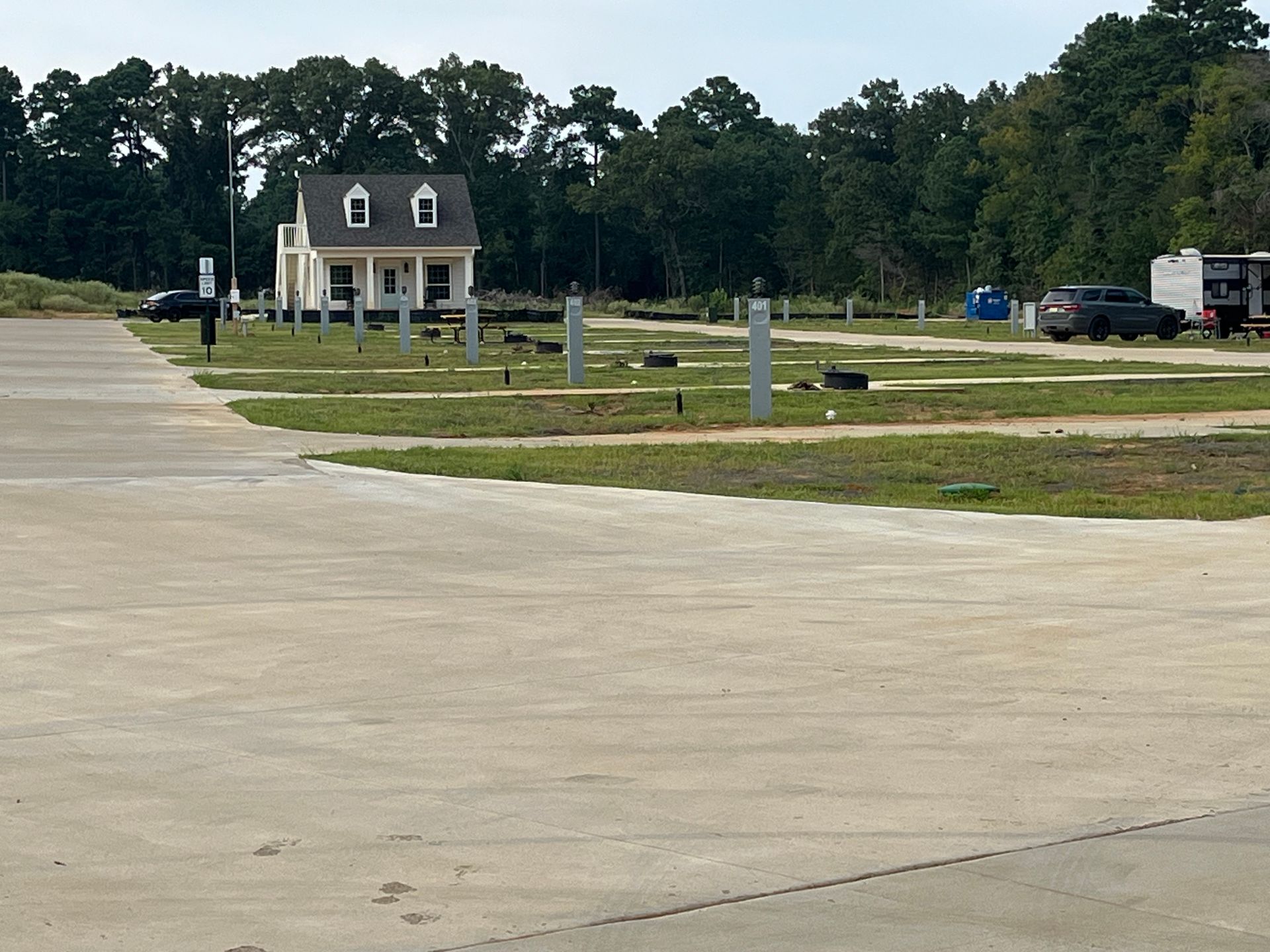 A small house is sitting in the middle of a parking lot.