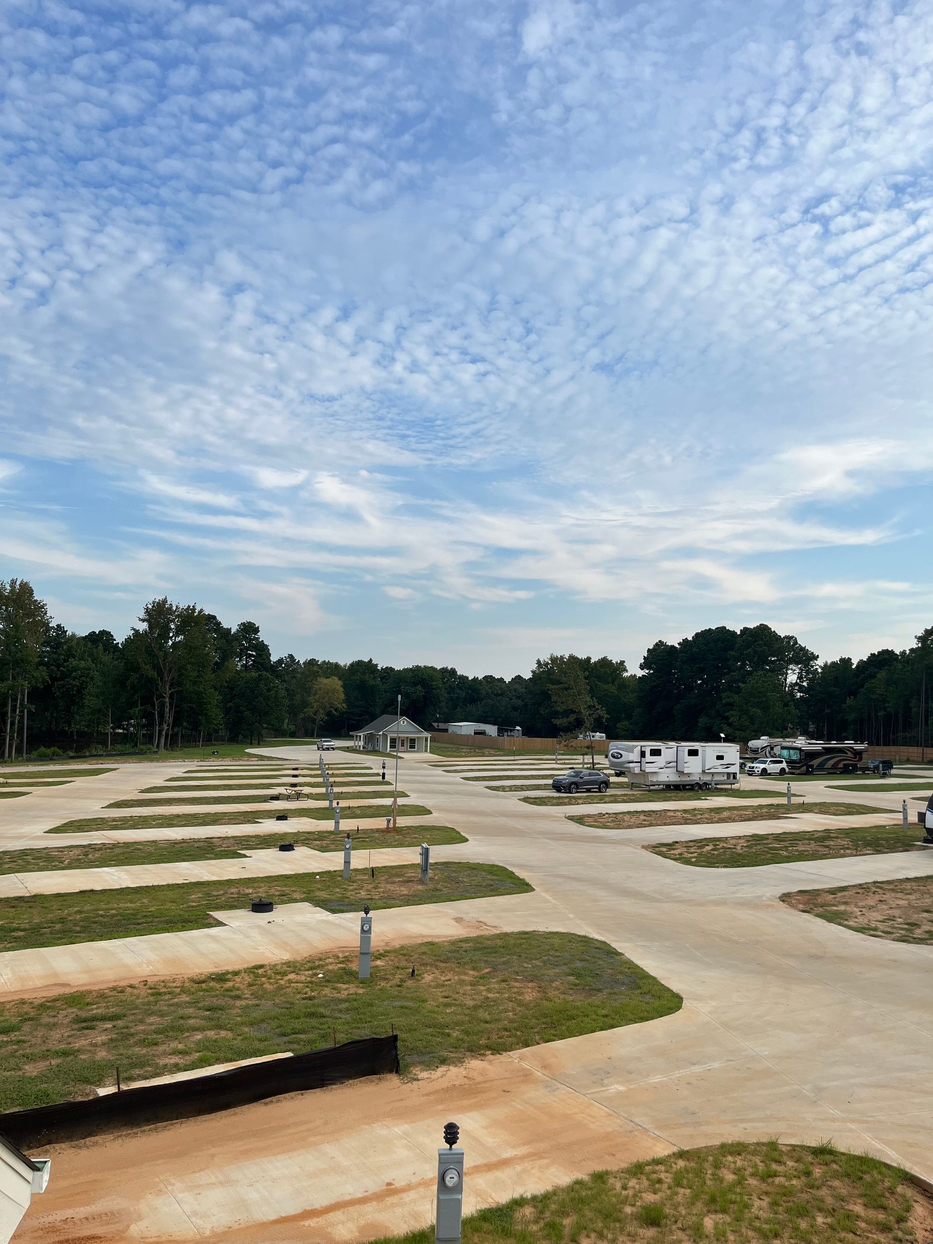 A rv park with a lot of grass and trees in the background