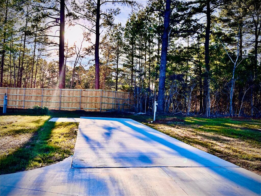 The sun is shining through the trees on the side of the road