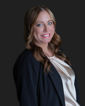 A woman in a black shirt is posing for a picture with her arms crossed.