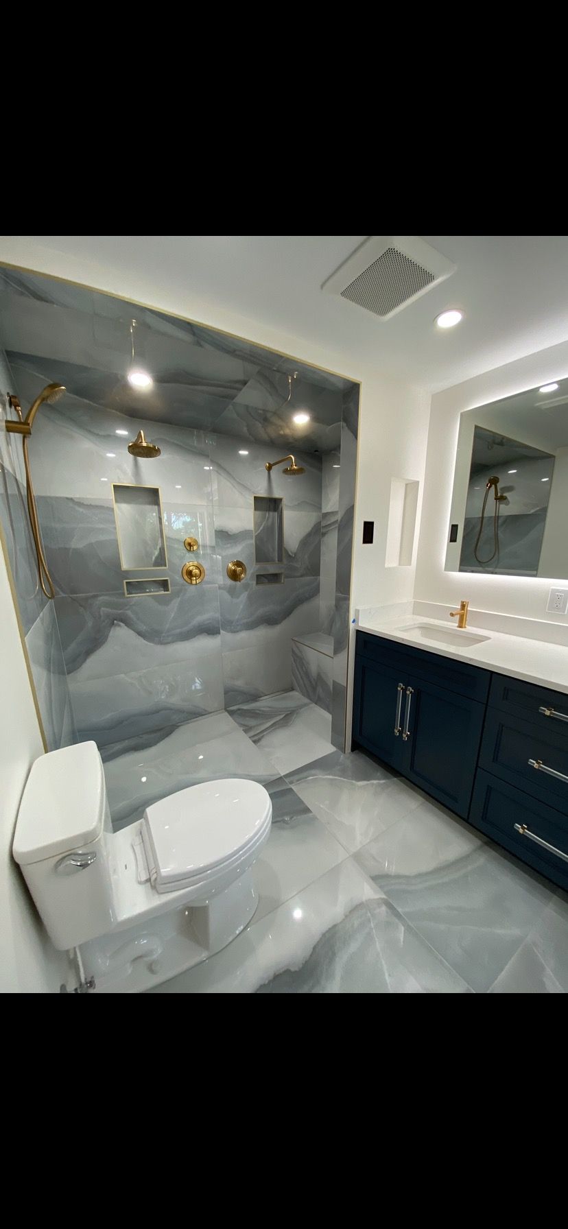 A bathroom with a toilet , sink and shower.
