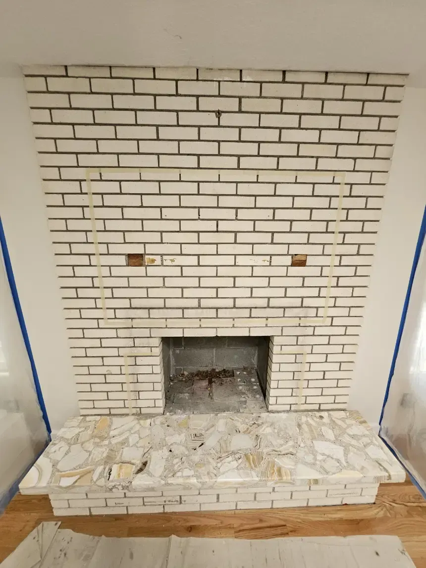 A white brick fireplace in a room with a wooden floor
