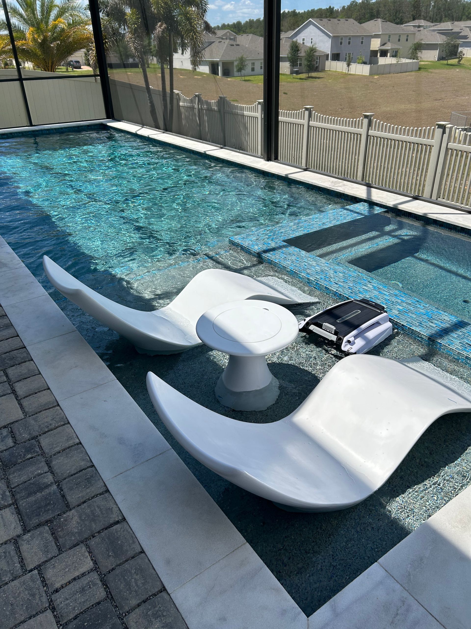 A swimming pool with two chairs and a table in front of it