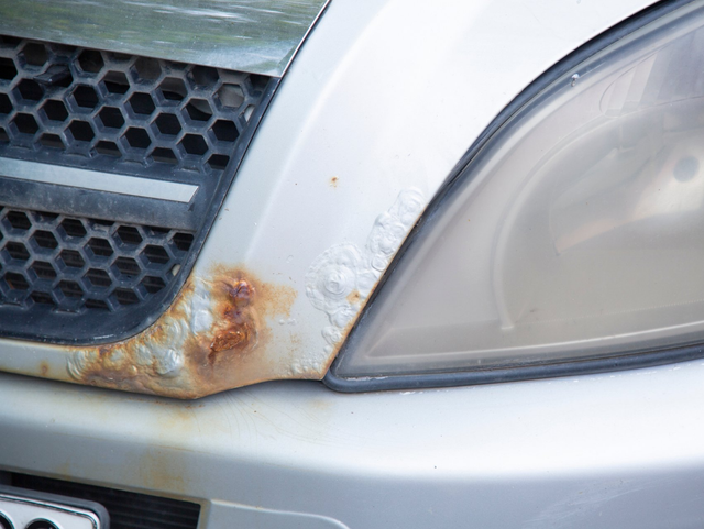 un gros plan d un capot et d un phare de voiture rouillés