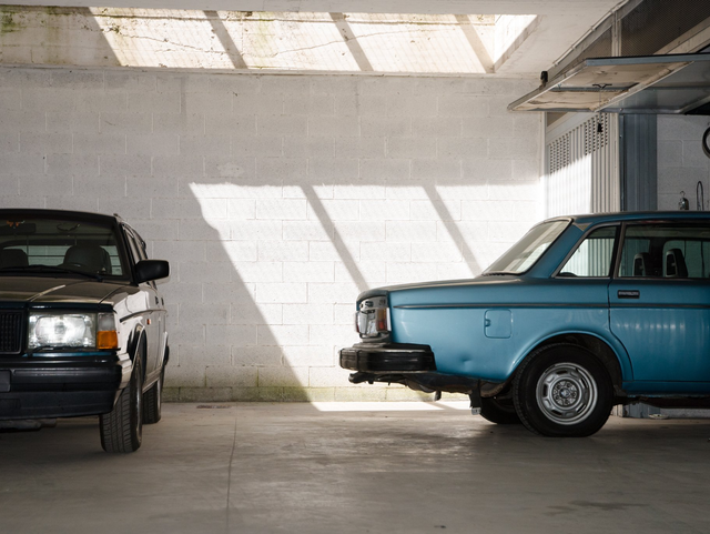 deux voitures sont garées l une à côté de l autre dans un garage.