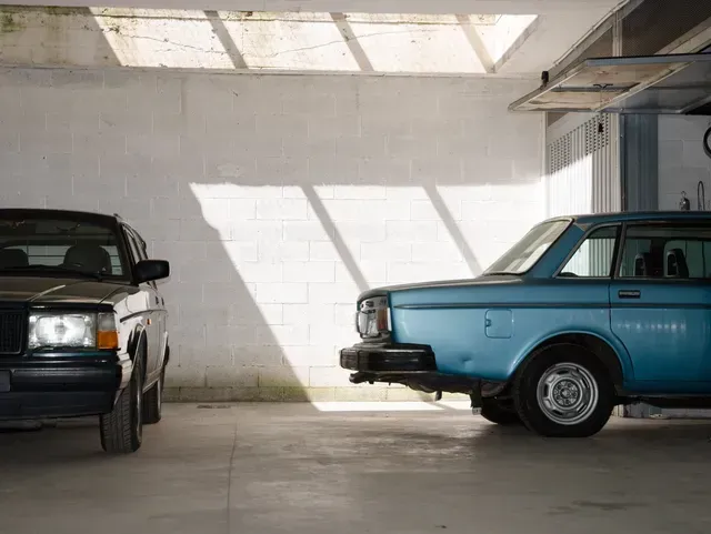 deux voitures sont garées l une à côté de l autre dans un garage.