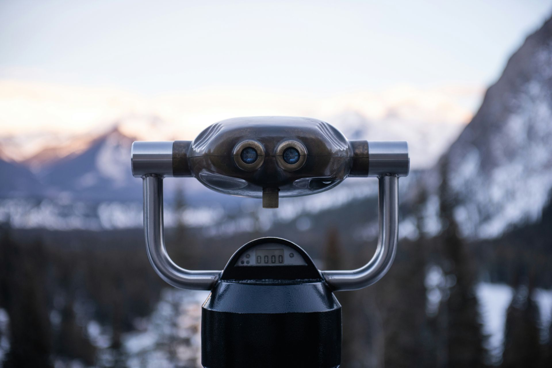 Binoculars overlooking mountains and a snowy landscape.