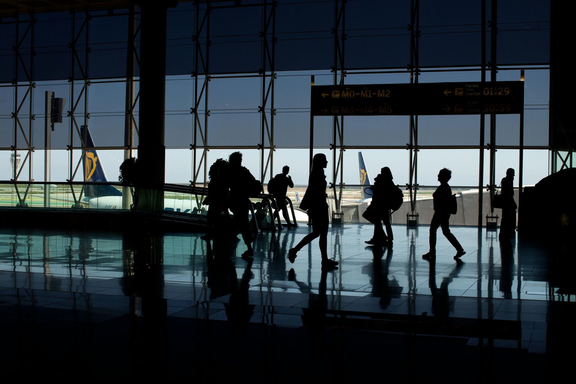 A group of people are walking through an airport terminal.