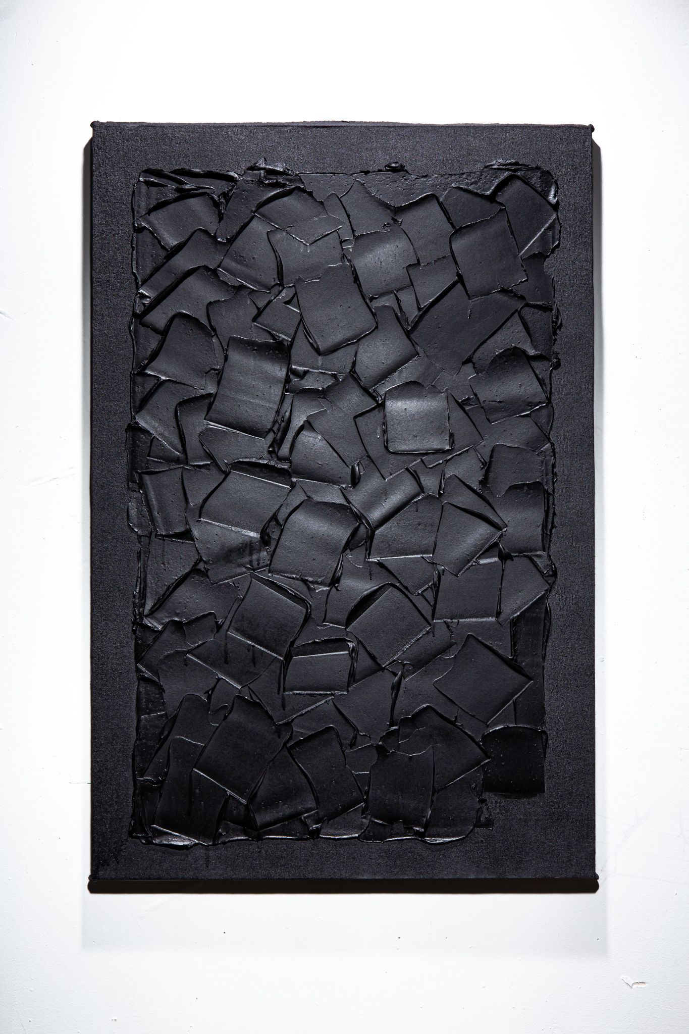 Black abstract painting with textured, square shapes within a dark frame; art by Matt Remsbecher. 