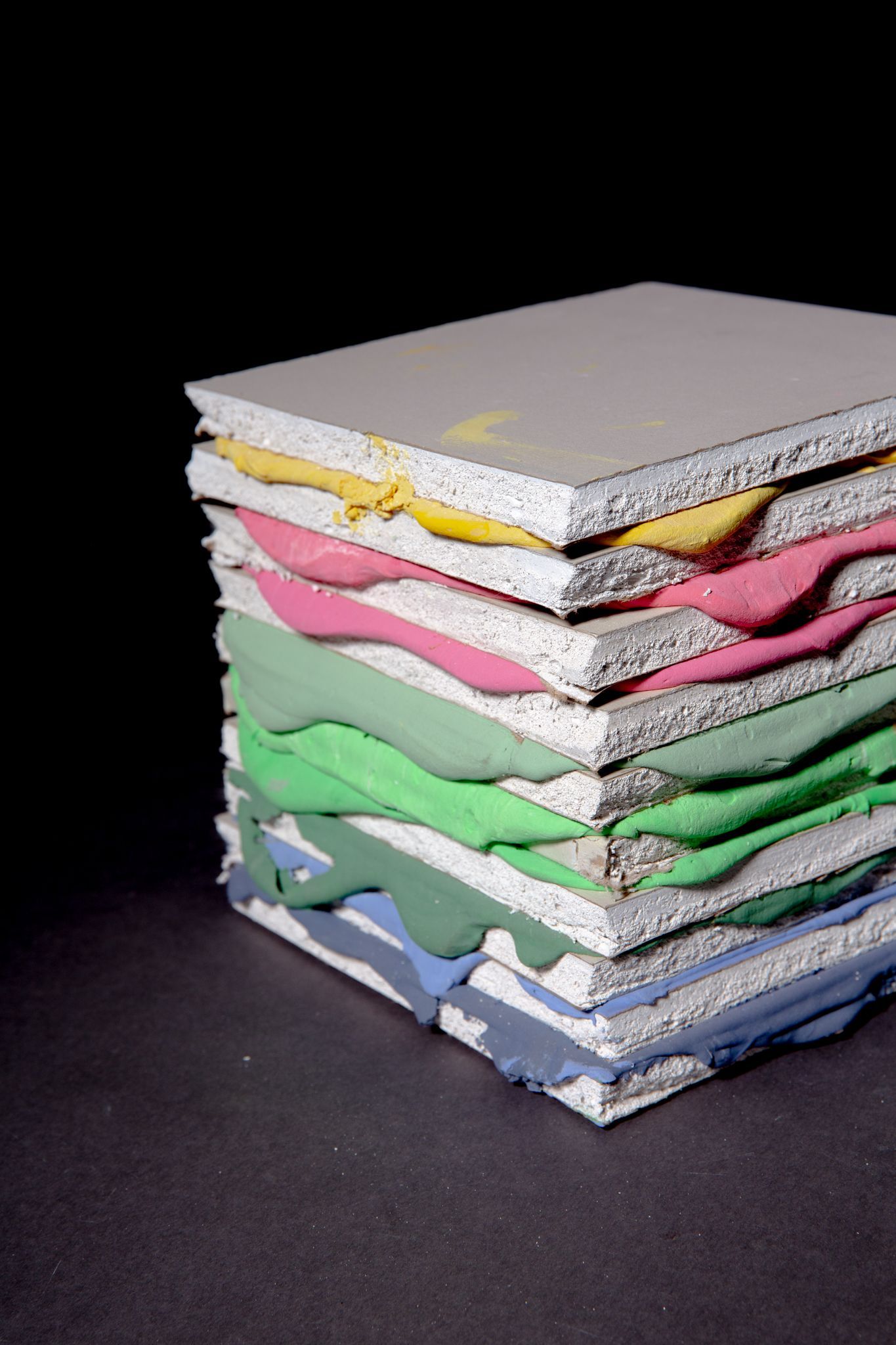 Stack of layered, colorful textured panels. Edges reveal paint of various colors; art by Matt Remsbecher. 