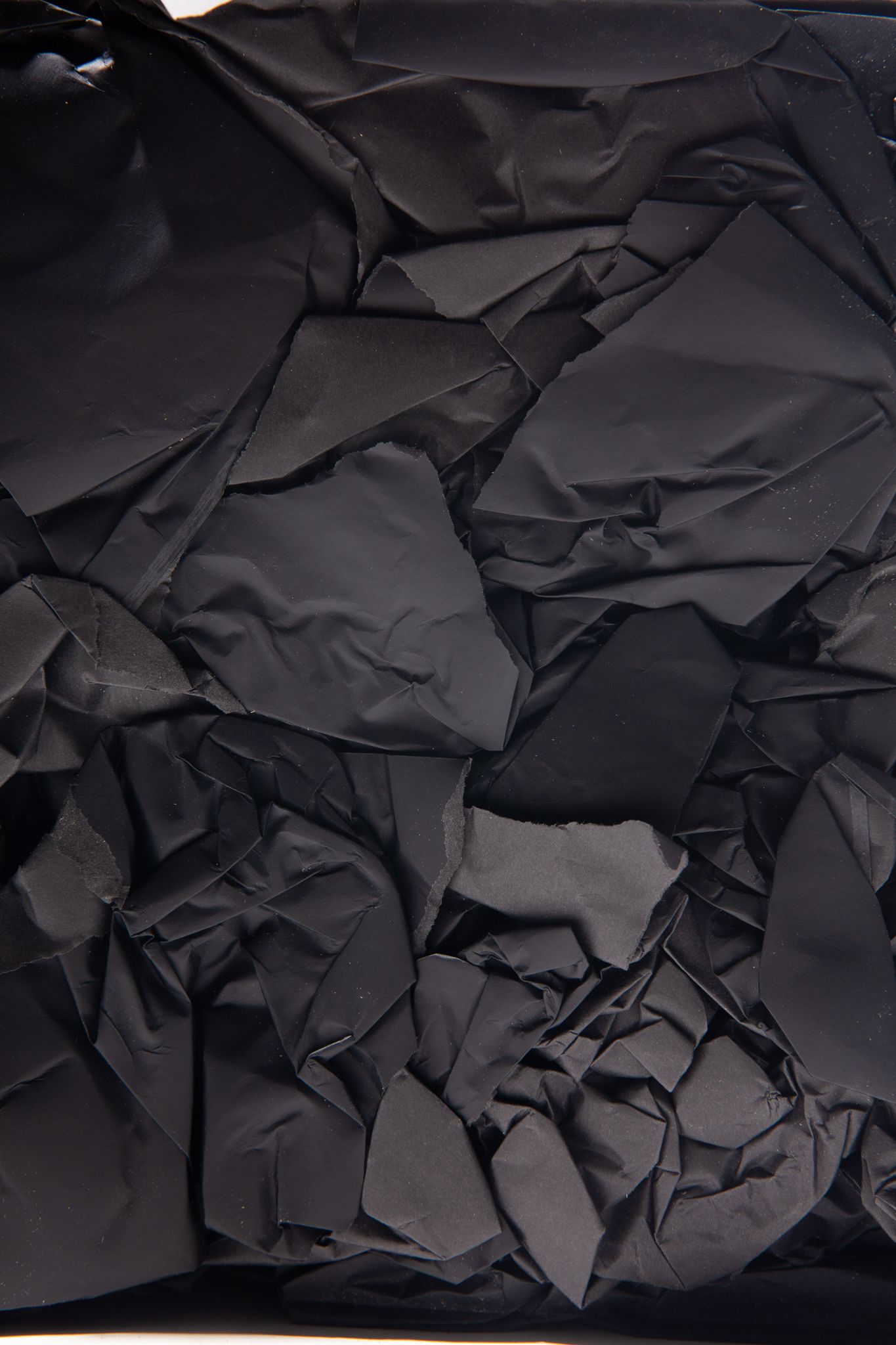 Crinkled black paper, texture with sharp angles and folds, dark shadows; art by Matt Remsbecher. 