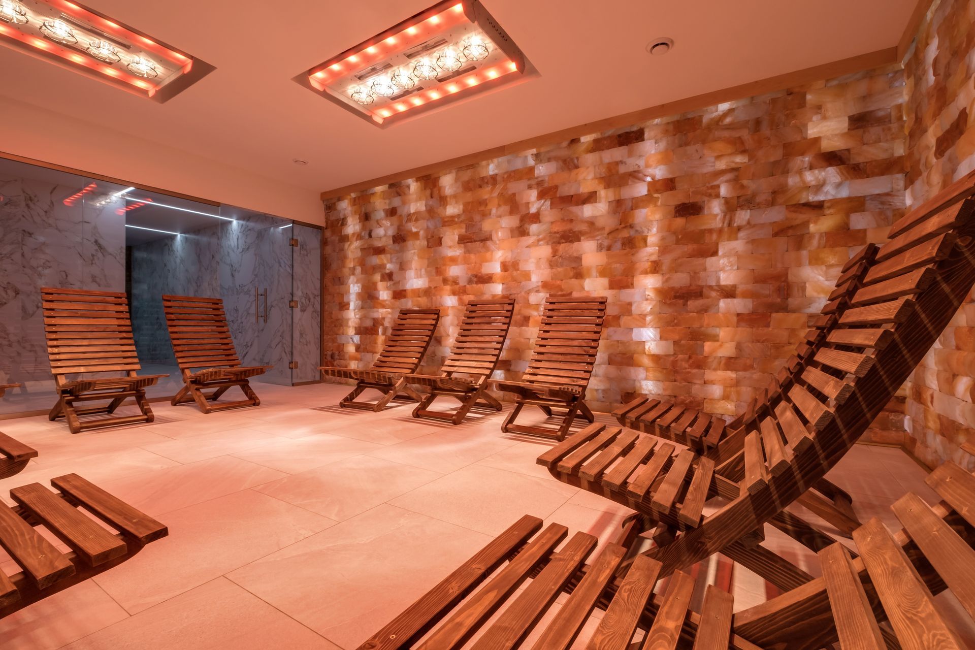A room filled with wooden chairs and a brick wall.