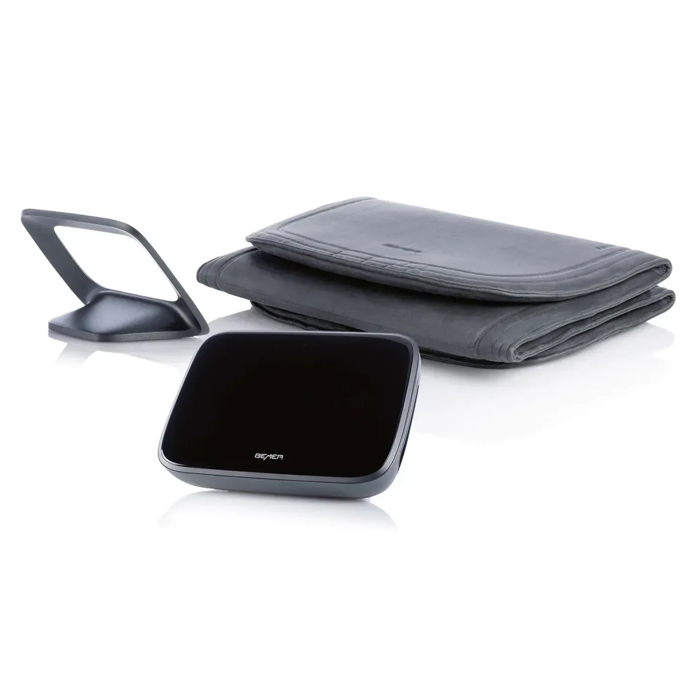 A small black device is sitting next to a wallet on a white surface.