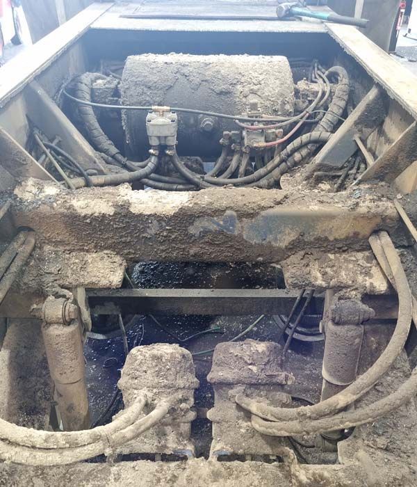 A dirty truck with a lot of wires coming out of it.
