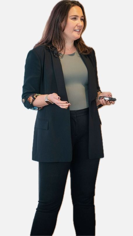 Woman in black blazer presenting, gesturing with one hand, holding a device in the other.