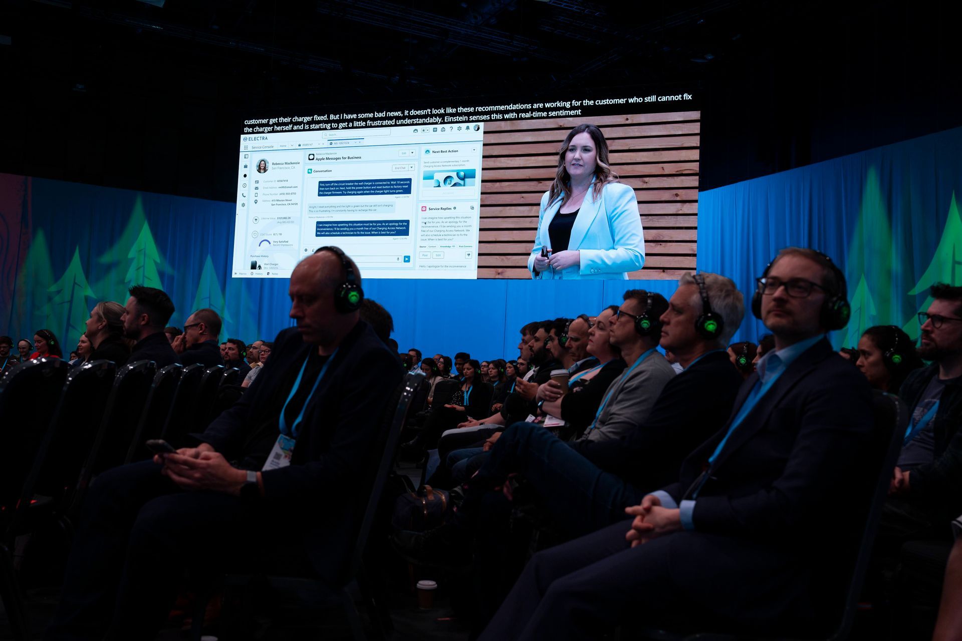 Rebecca presenting on screen to a large audience