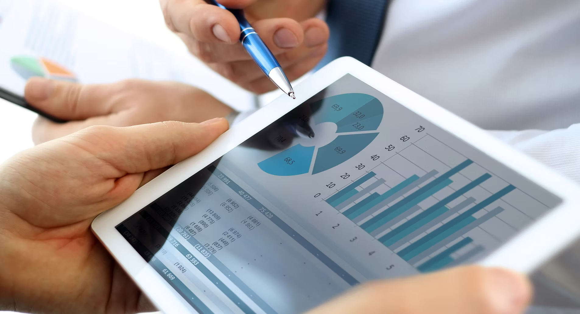 Hands Pointing at a Tablet Displaying Charts and Graphs — Compago Technologies In Cambridge, TAS