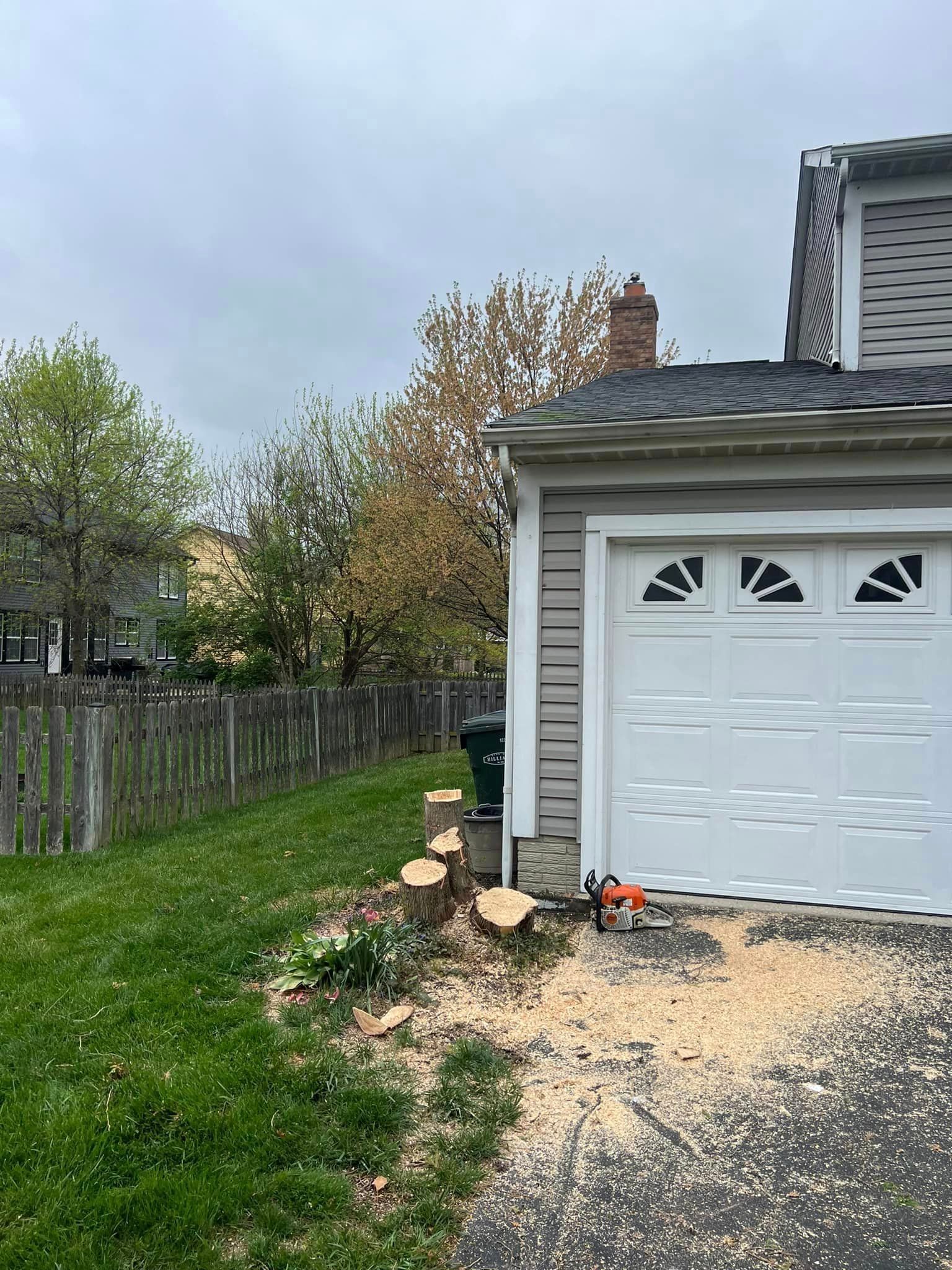 A tree stump is sitting in front of a garage door.