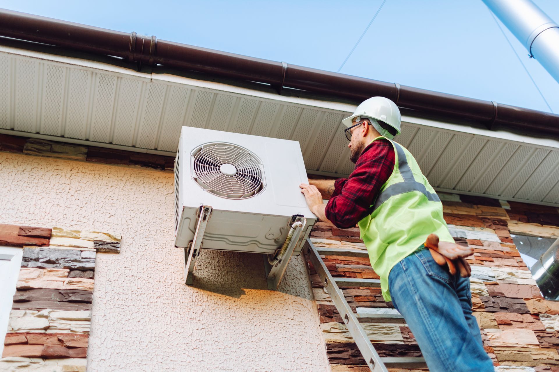Technician performing seasonal maintenance on residential heat pump to improve efficiency and long.