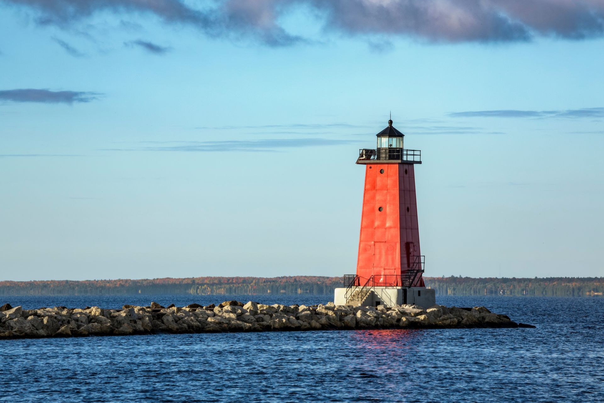 red lighthouse on an isle in the middle of the ocean in michigan