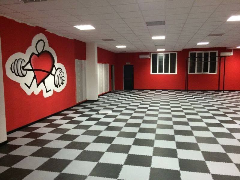 Stanza rossa vuota con pavimento a scacchi bianchi e neri e logo graffitato sulla parete.