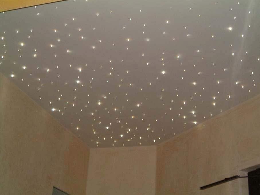 Soffitto ricoperto di piccole luci a forma di stella in una stanza beige