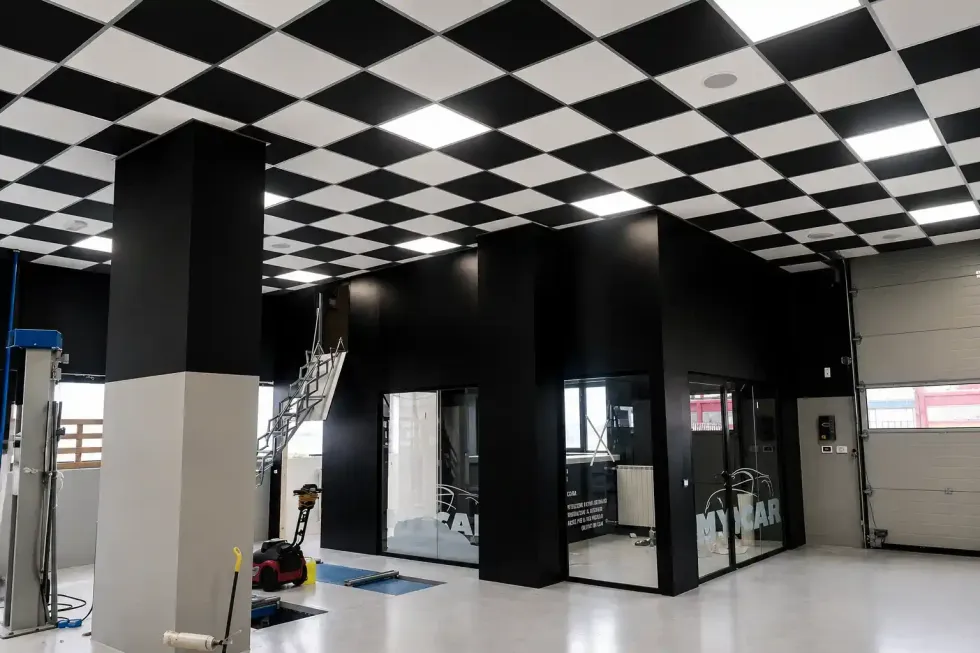 Interni moderni con soffitto a scacchi bianchi e neri e ufficio con pareti in vetro.