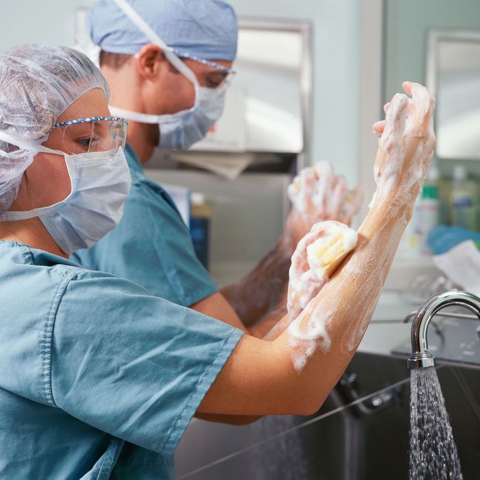 A man and a woman are washing their hands with soap