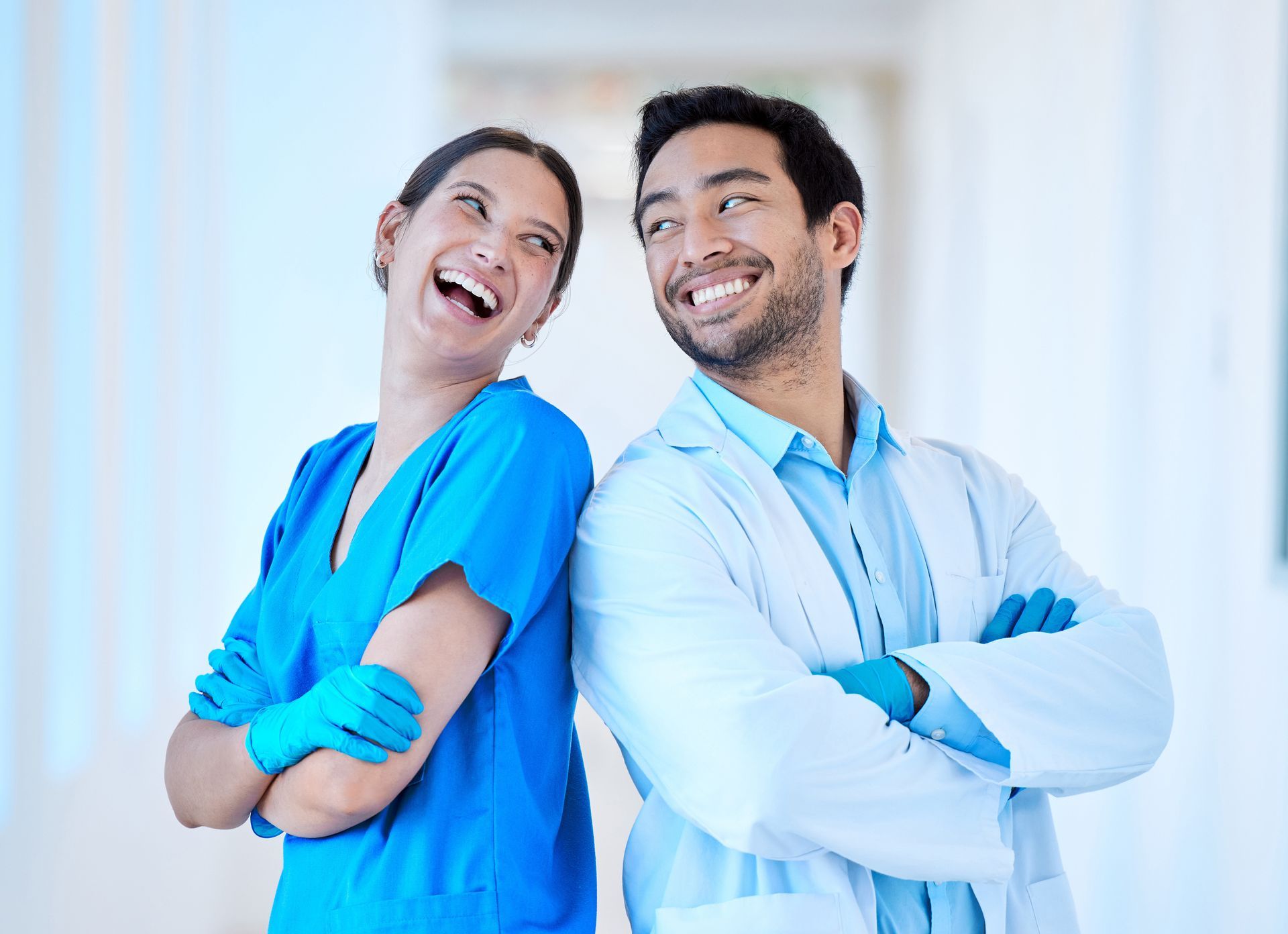 A man and a woman are standing next to each other with their arms crossed.