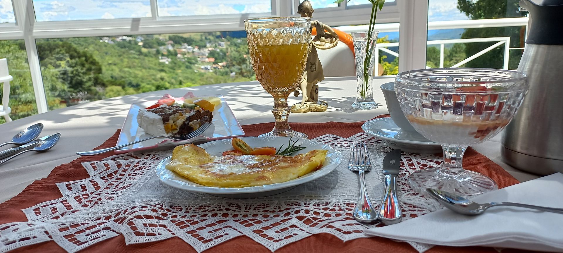 Uma mesa coberta com pratos de comida e um copo de suco de laranja.